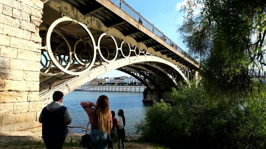 Seville: Guadalquivir & Secrets of Triana Small Group Tour - Crossing Isabel II Bridge into Triana